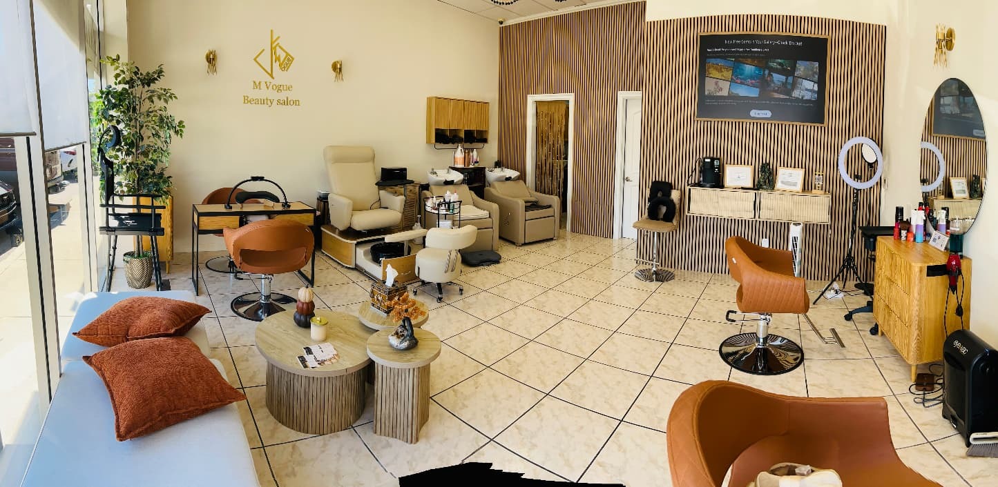 Interior of M Vogue Beauty Salon in Valley Village CA with round mirrors, warm wood styling stations and caramel leather chairs